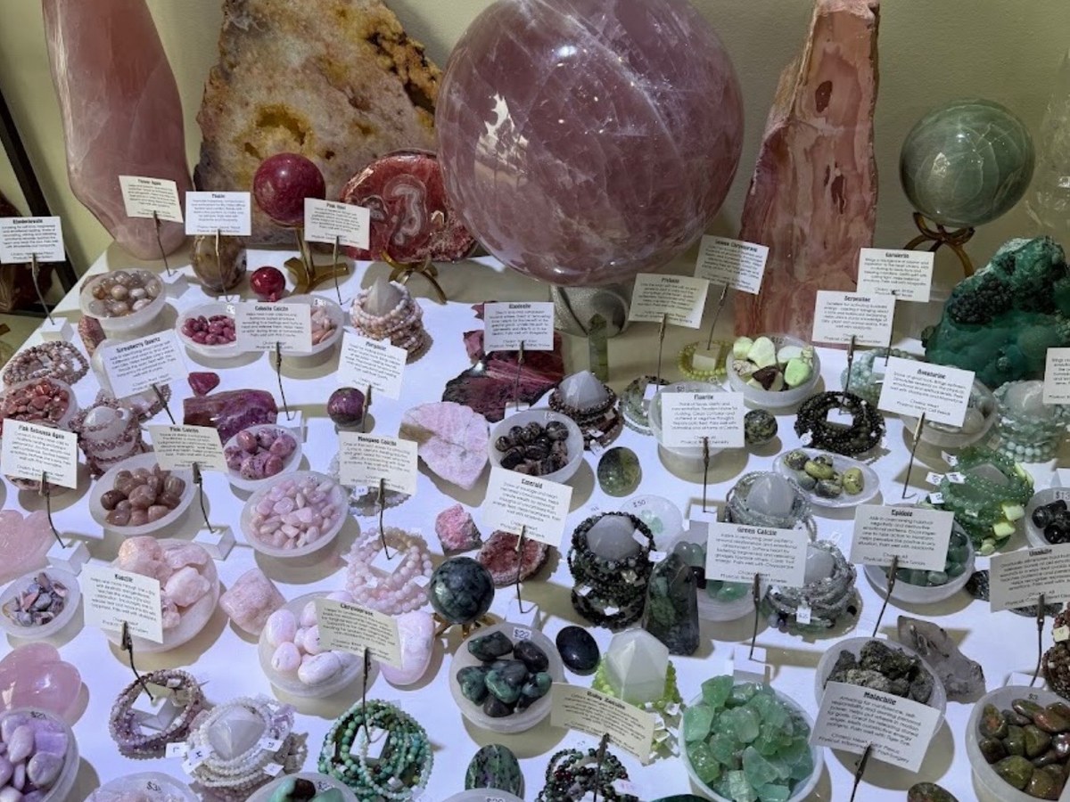 Display table of rose quartz spheres, pink calcite and gemstone bracelets